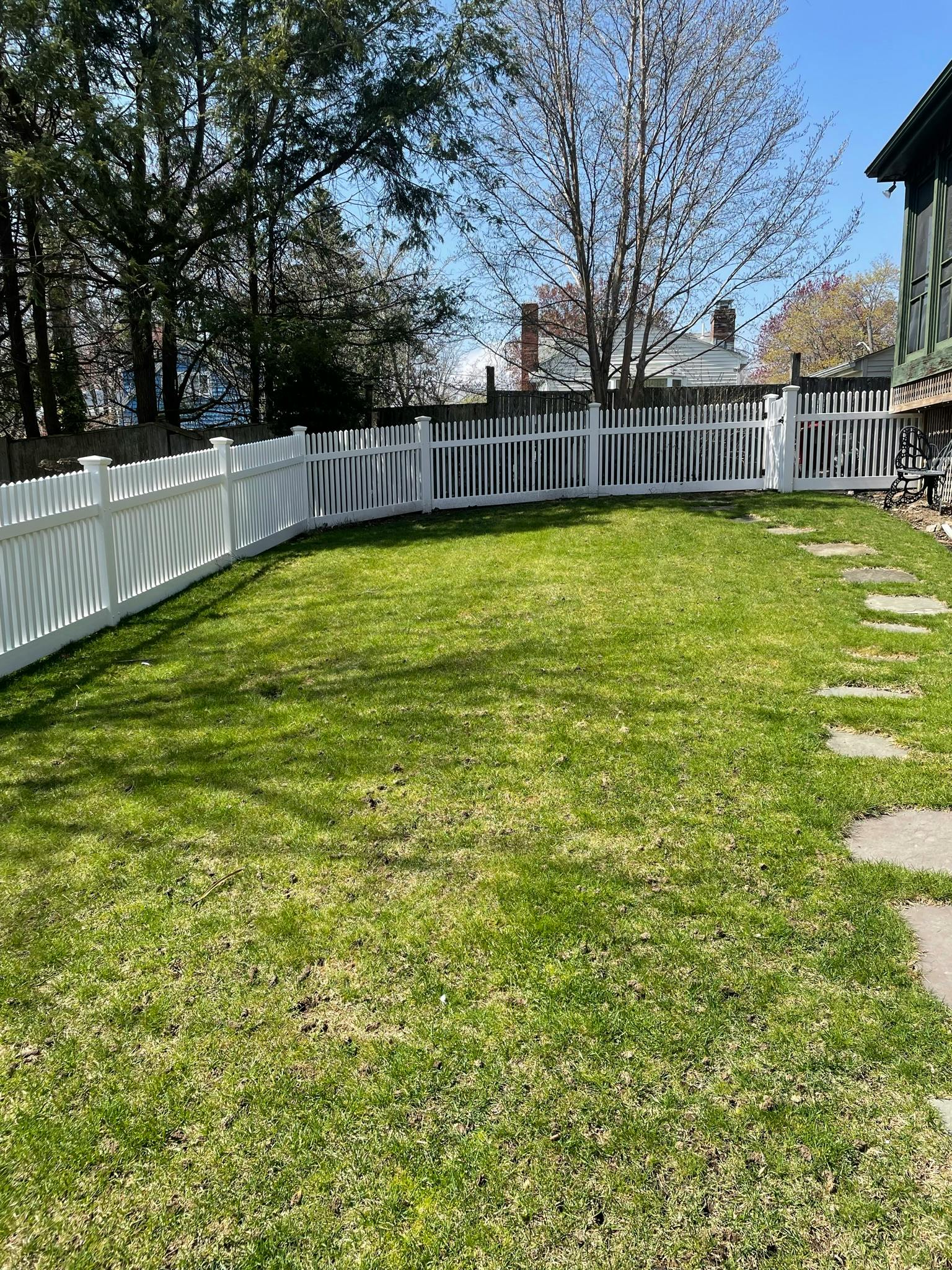 Green lawn with a white picket fence