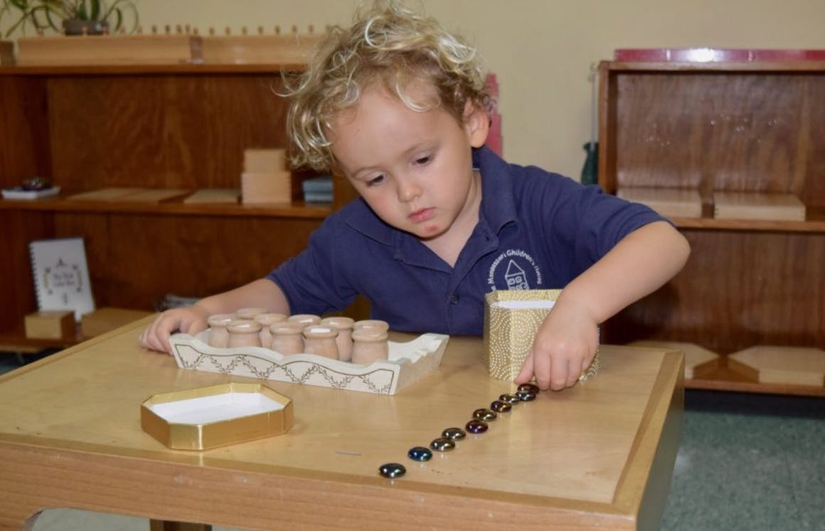 Child playing with small objects on a table