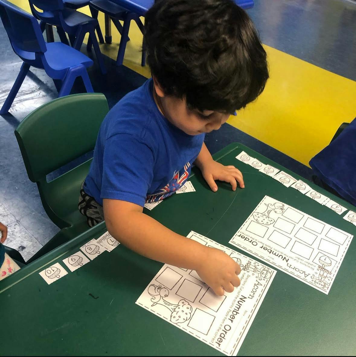 Child working on a number order activity at a table