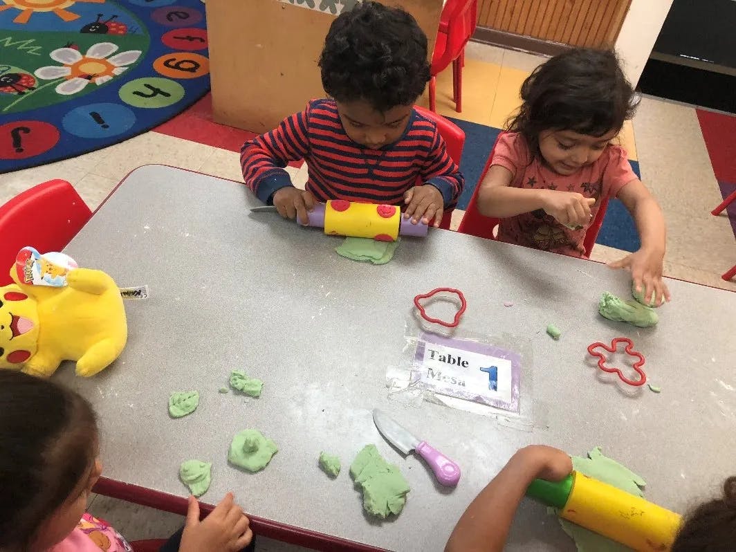 Children playing with playdough at a table
