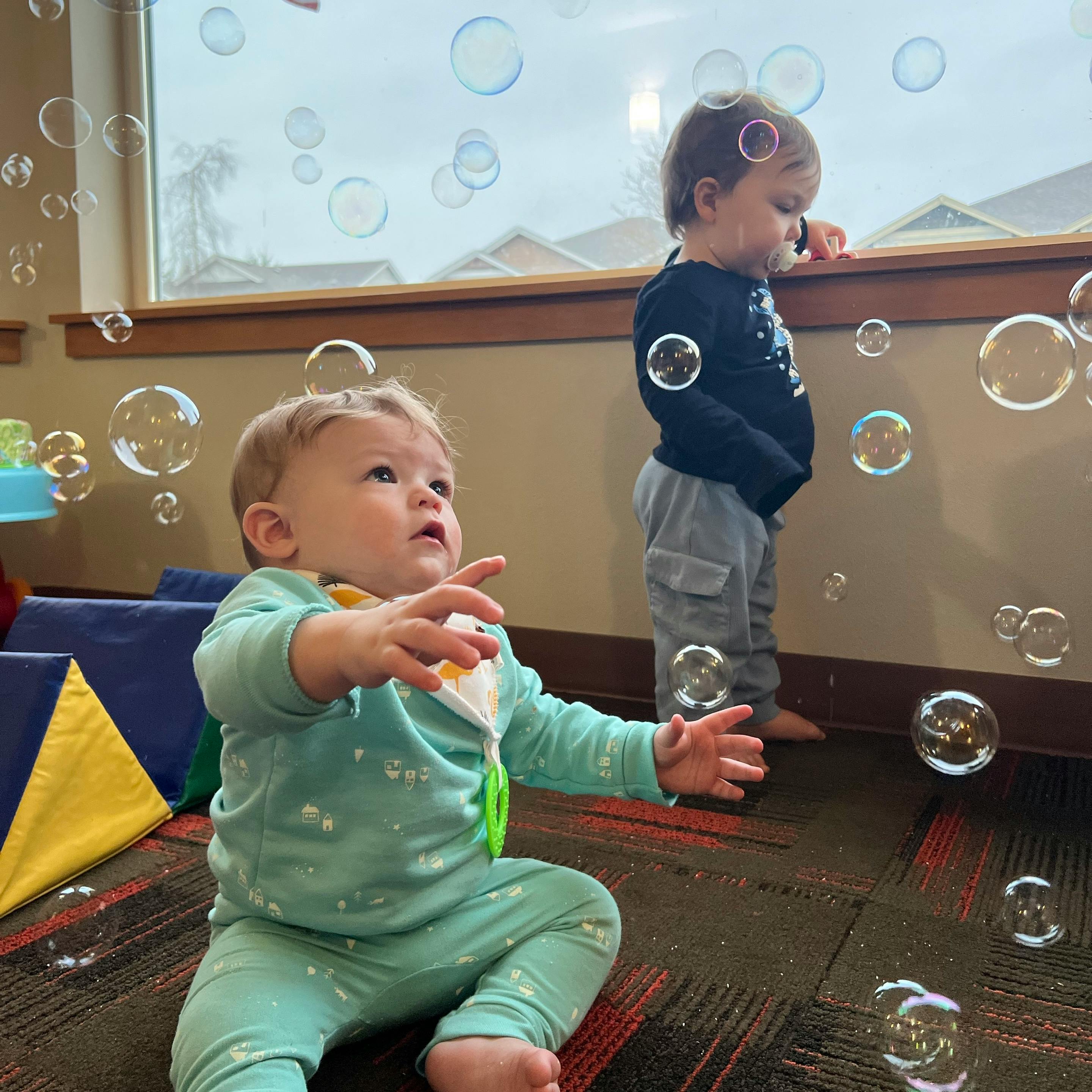 Two children playing with bubbles