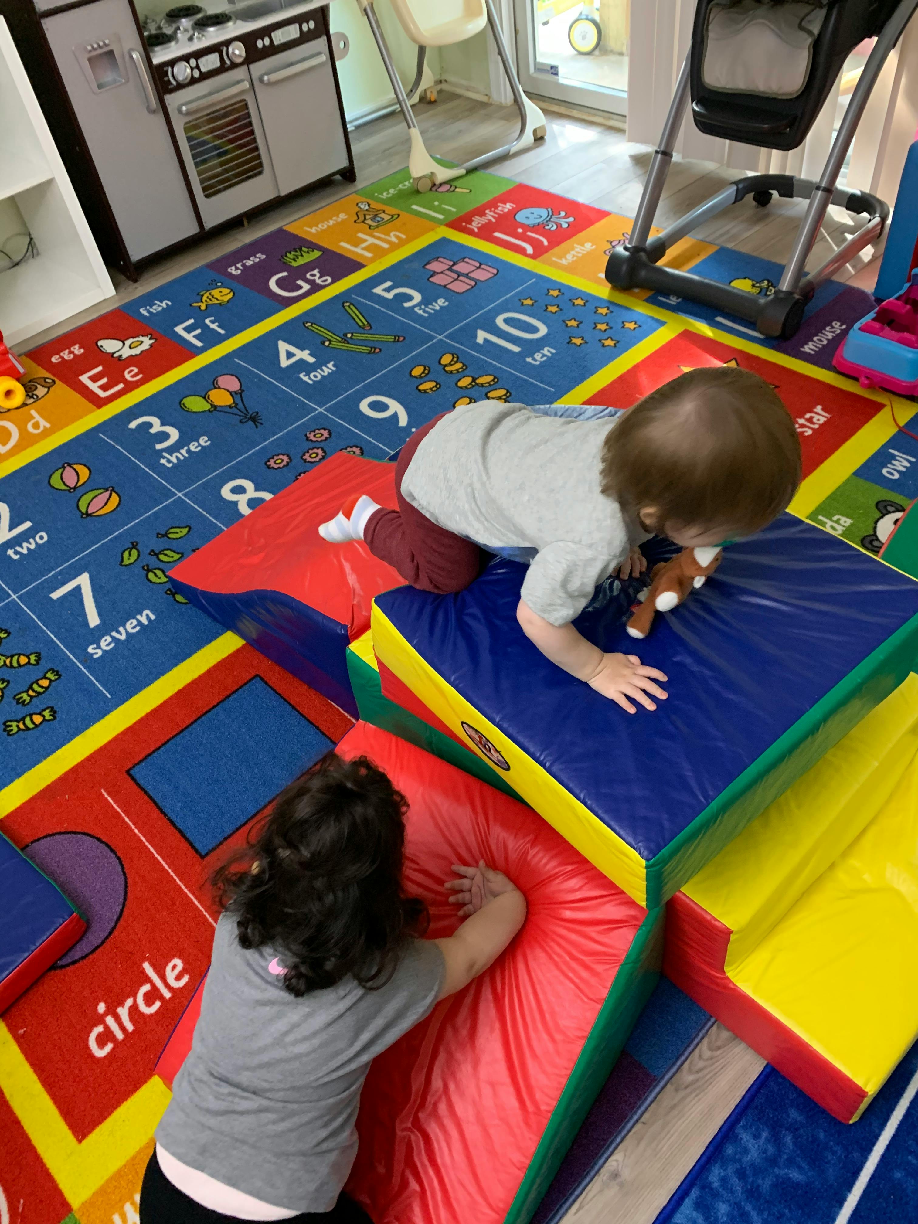 Two children playing on colorful soft play mats