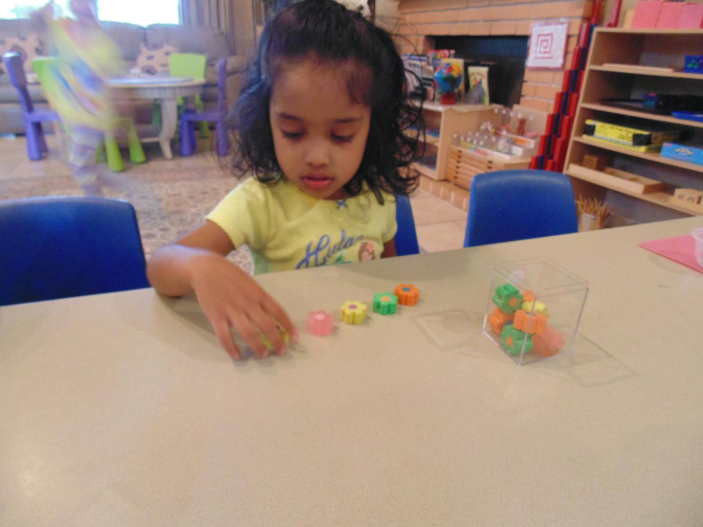Child playing with colorful counting blocks at a table