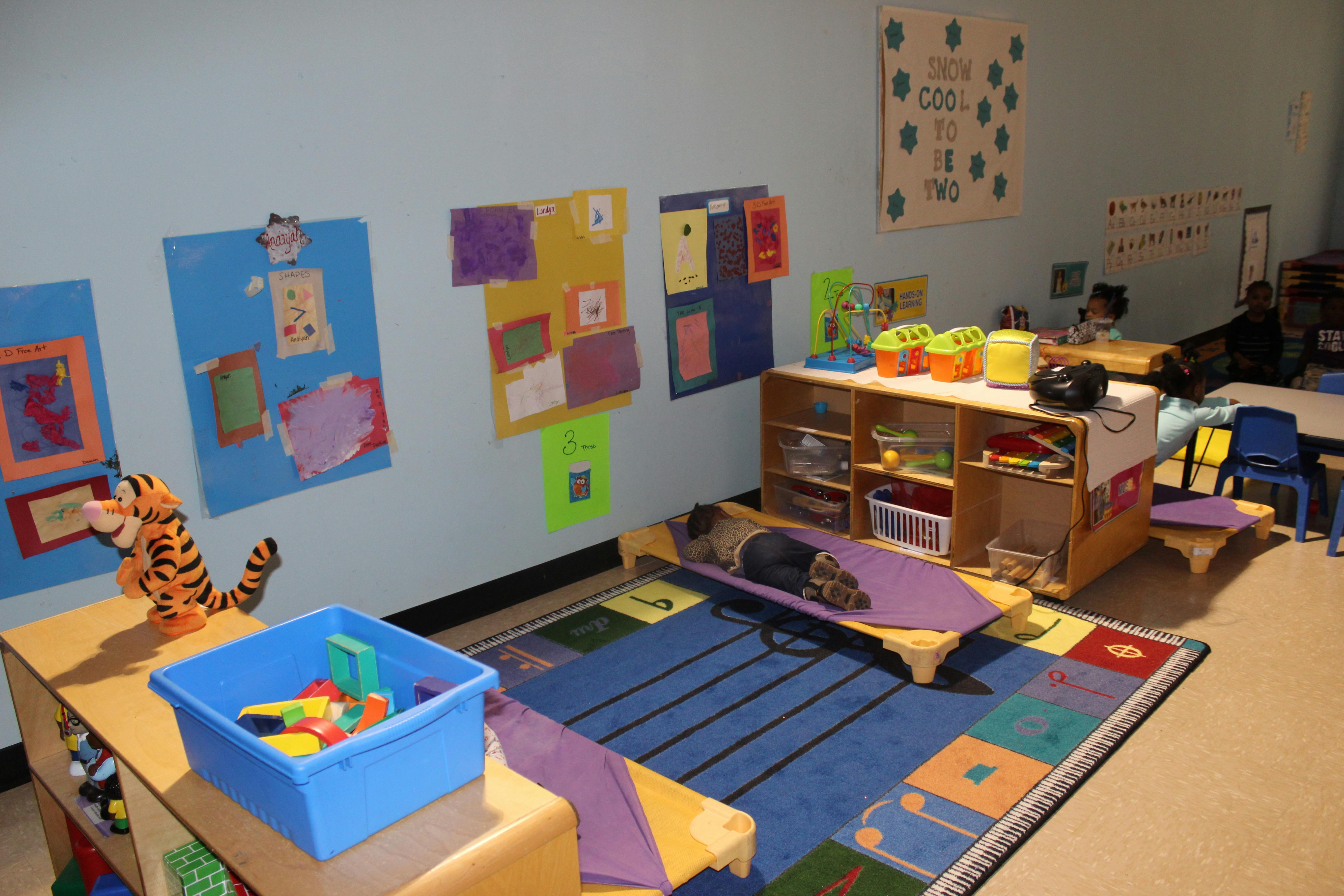 Child sleeping on a cot in a classroom