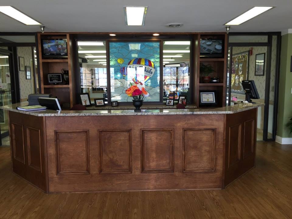 Reception desk with a floral arrangement and a colorful hot air balloon decoration