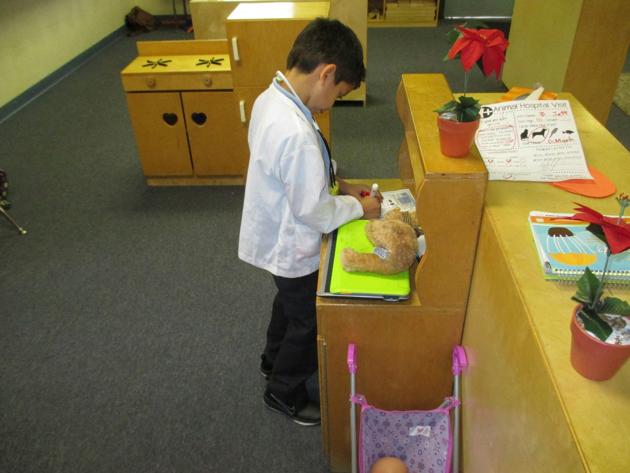 Child in white coat writing on clipboard with stuffed animal