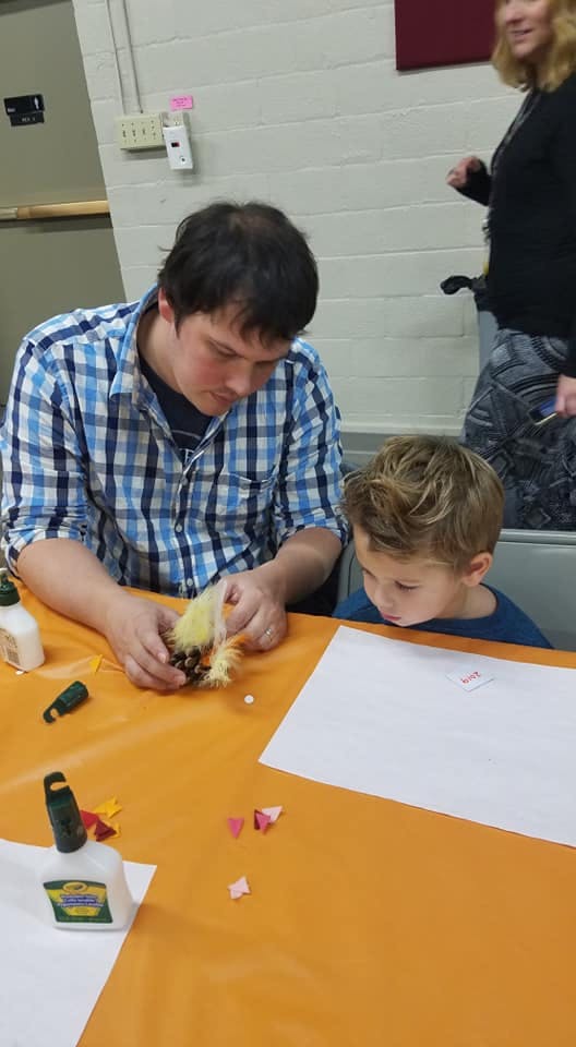 Person and child crafting at a table
