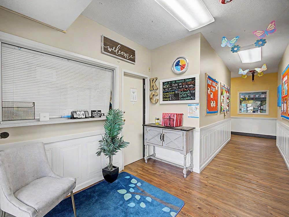 A hallway with a welcome sign and a whiteboard with text in a building