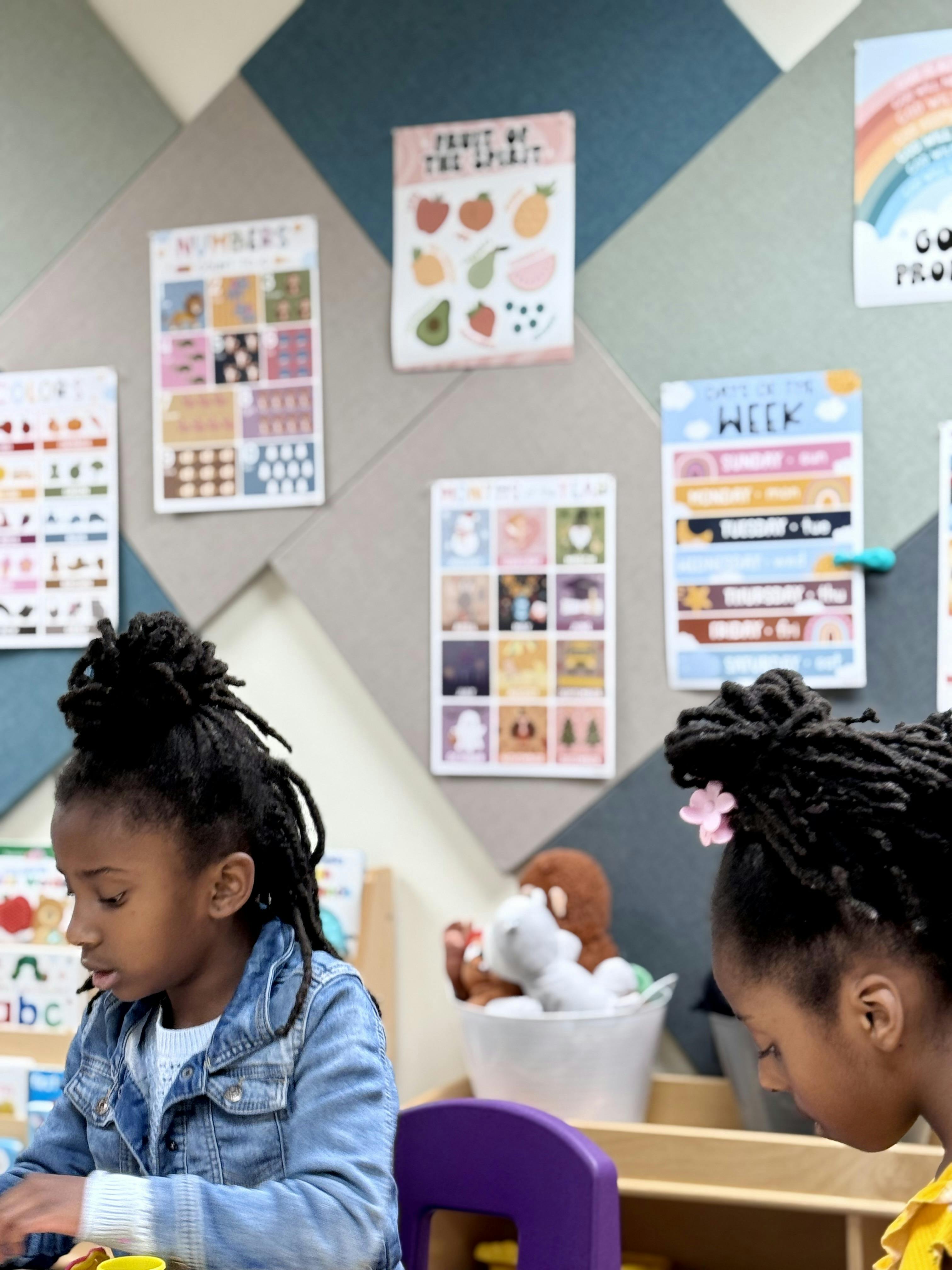 Two children sitting at a table in a classroom