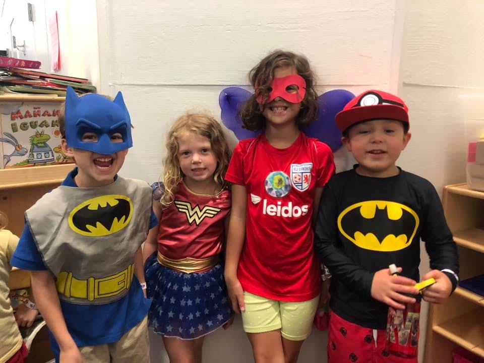 Four children in superhero costumes