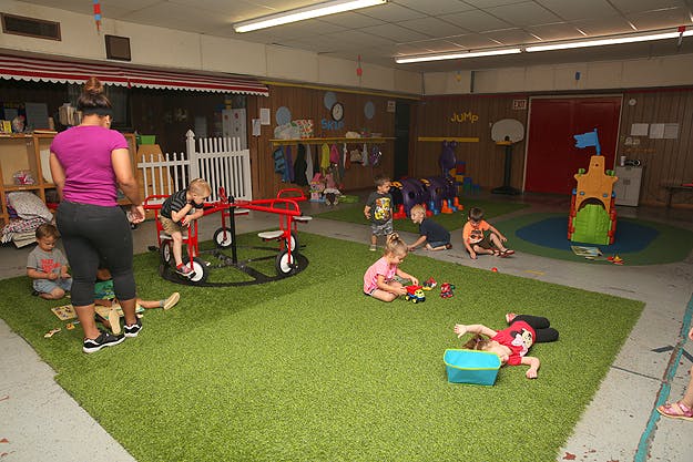 Adult supervising children playing in an indoor play area