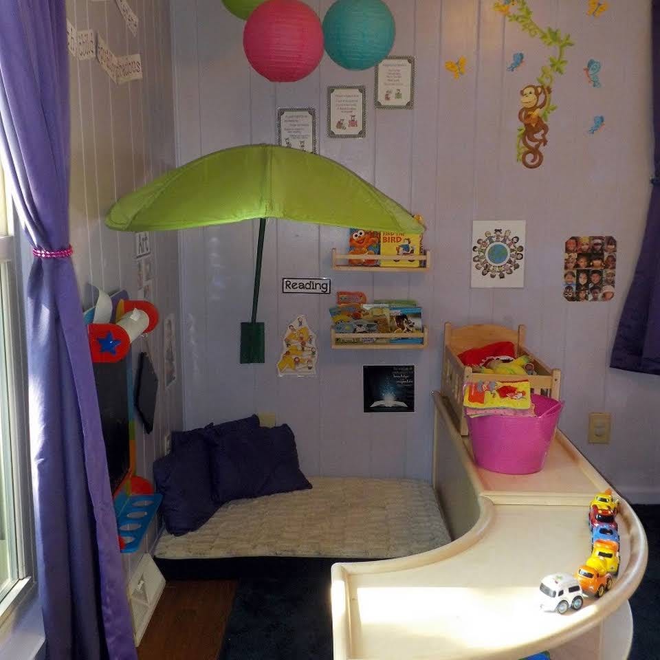 Children's reading nook with a green umbrella, books, and toys