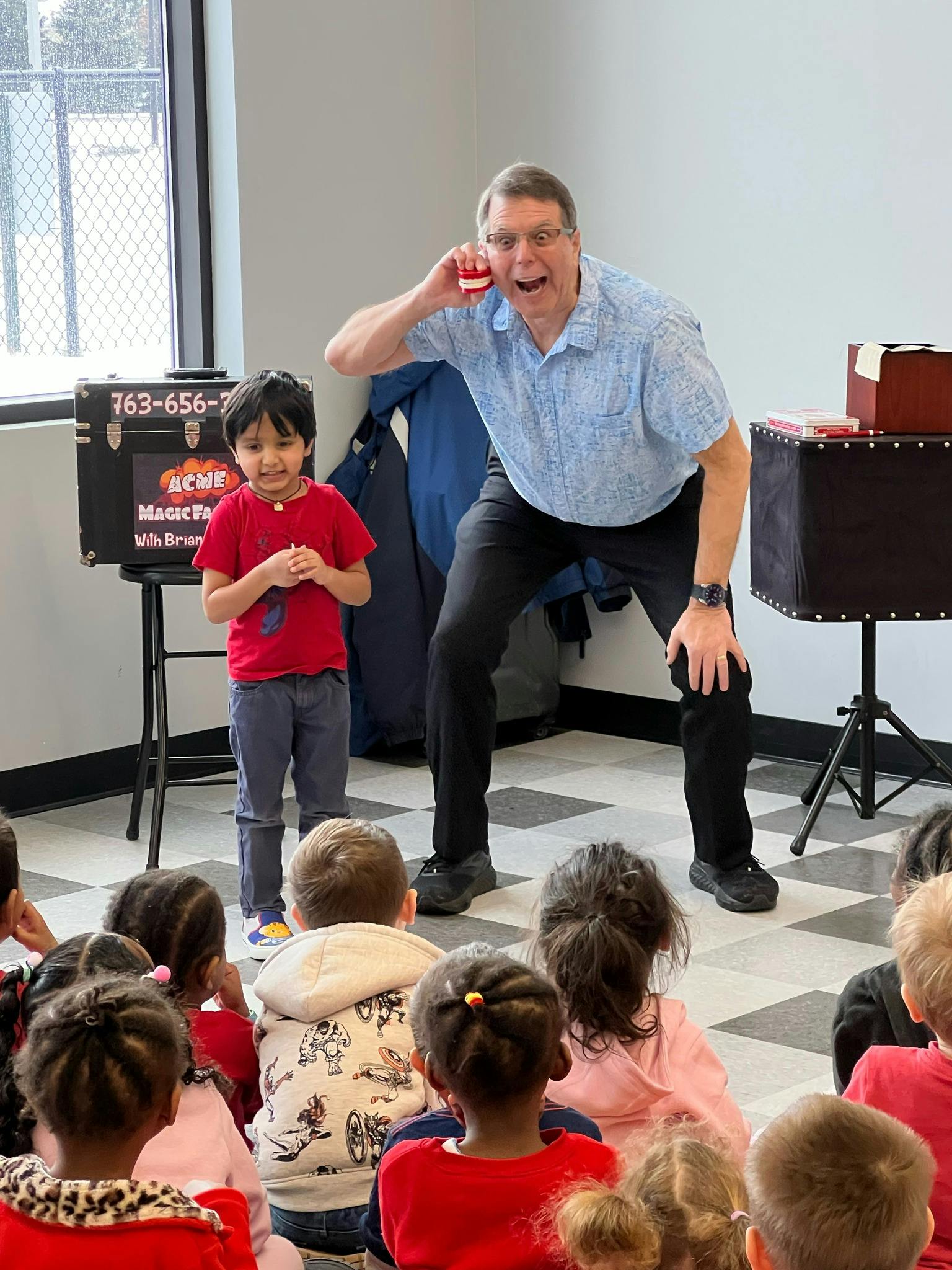 Adult and child performing for a group of children