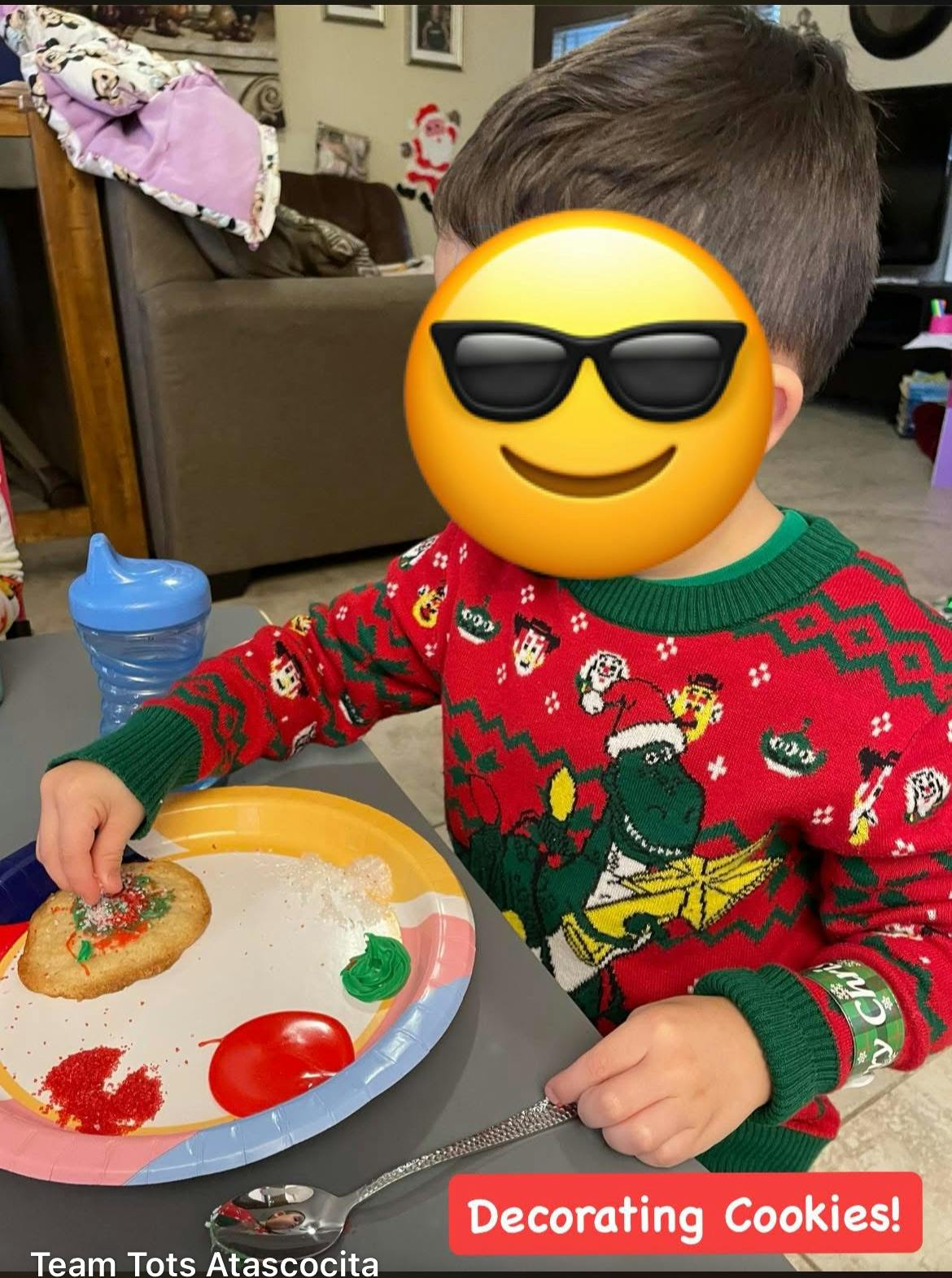 Child decorating a cookie on a paper plate