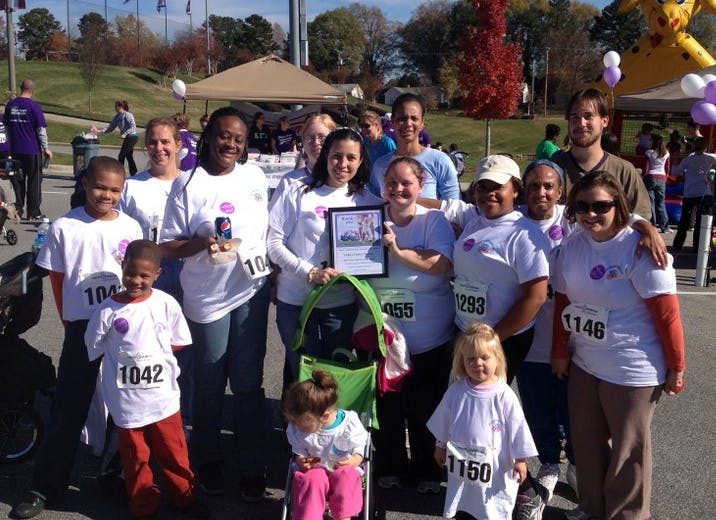 Group of people and children in white shirts with race numbers