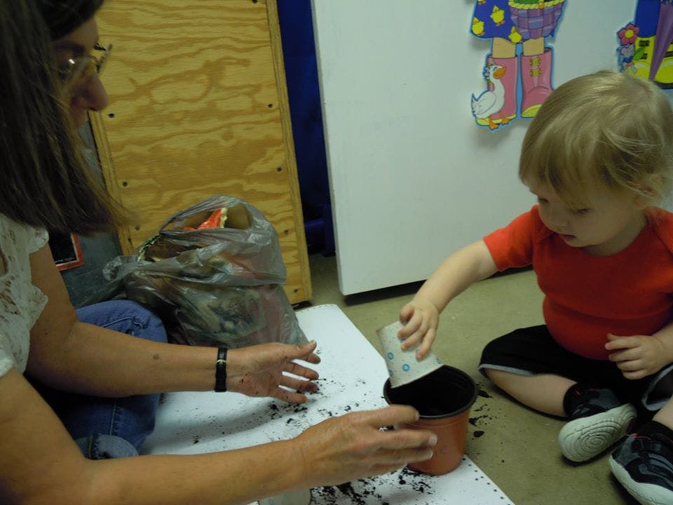 Person and child planting in a pot