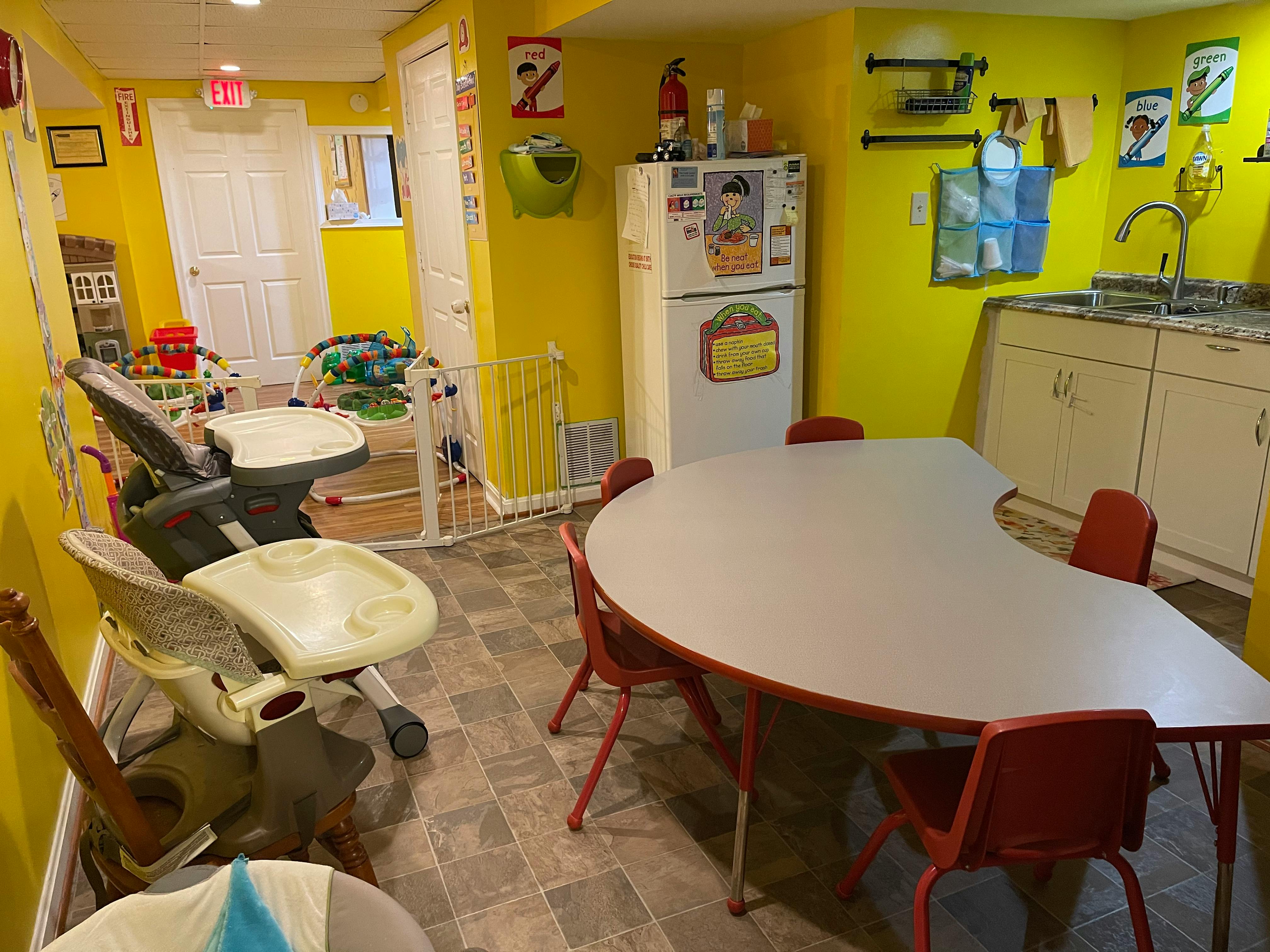 Daycare room with a crescent-shaped table and high chairs