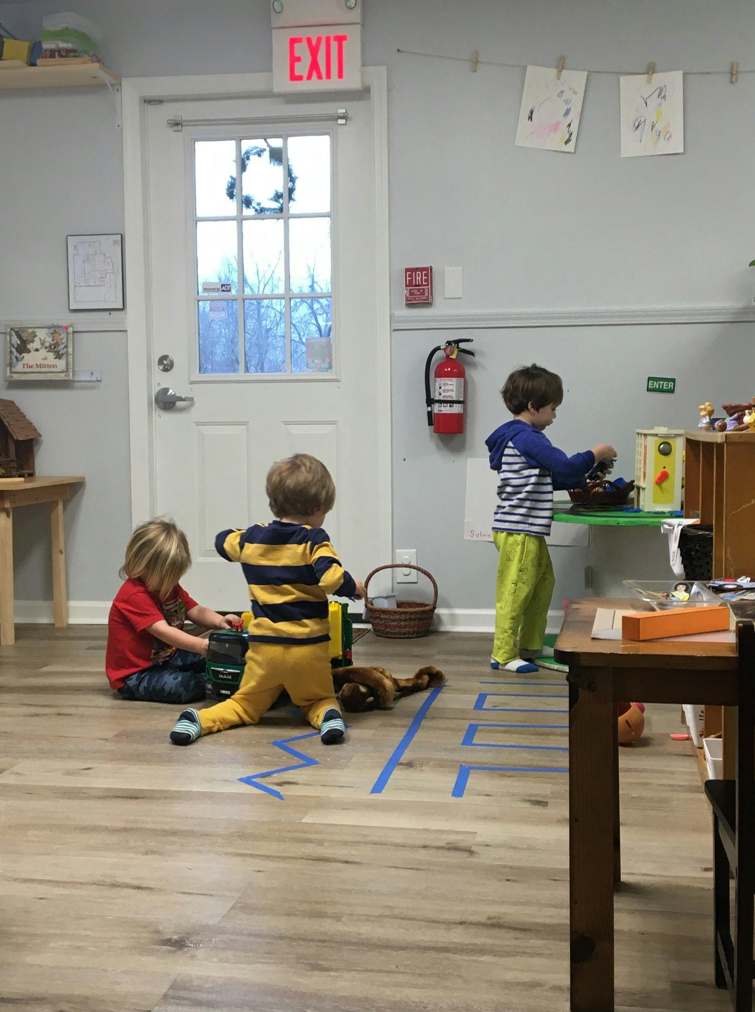 Three children playing with toys in a room