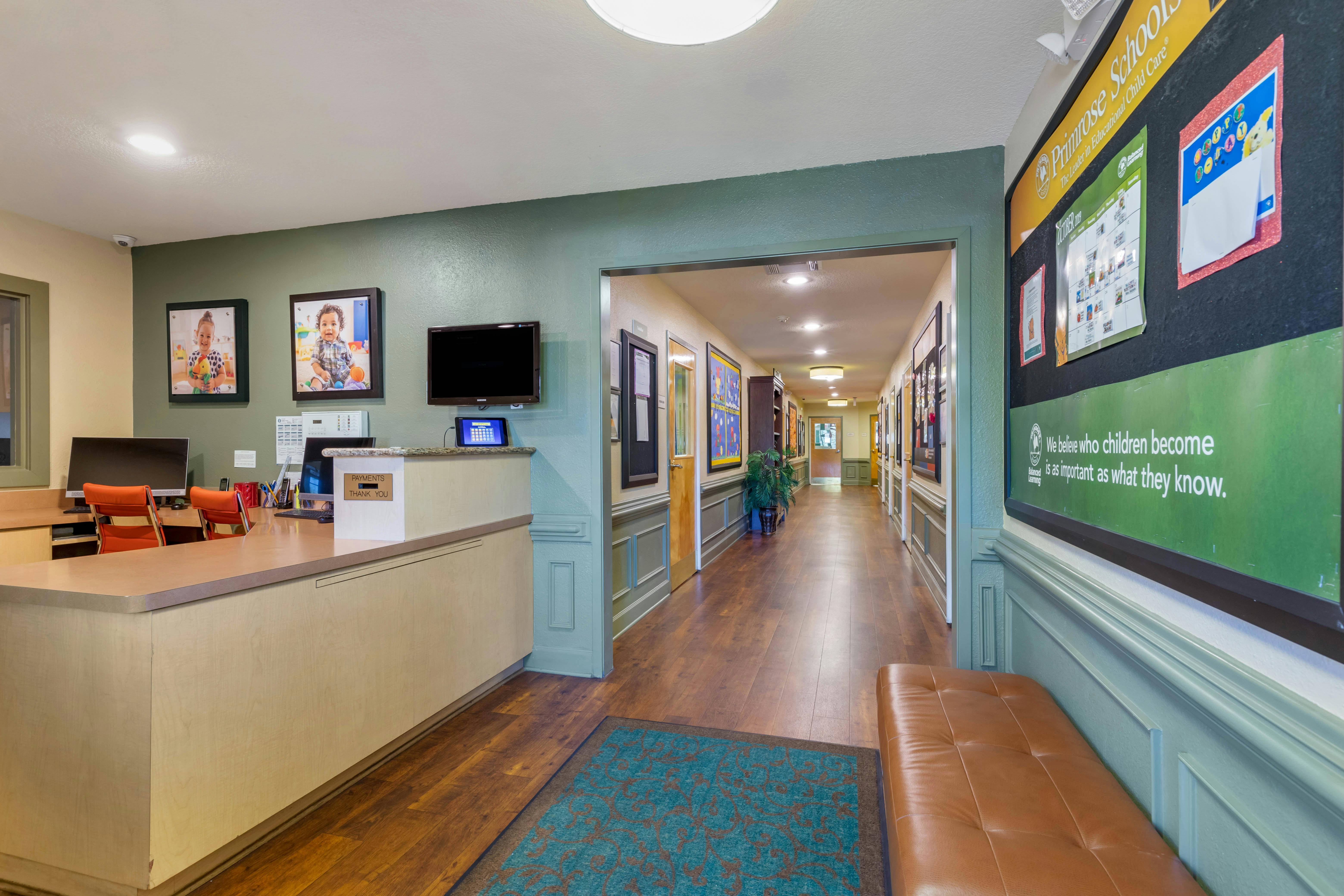 Reception area with a light wood counter, a long hallway visible in the background