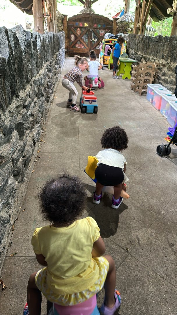Children playing with toys on a pathway