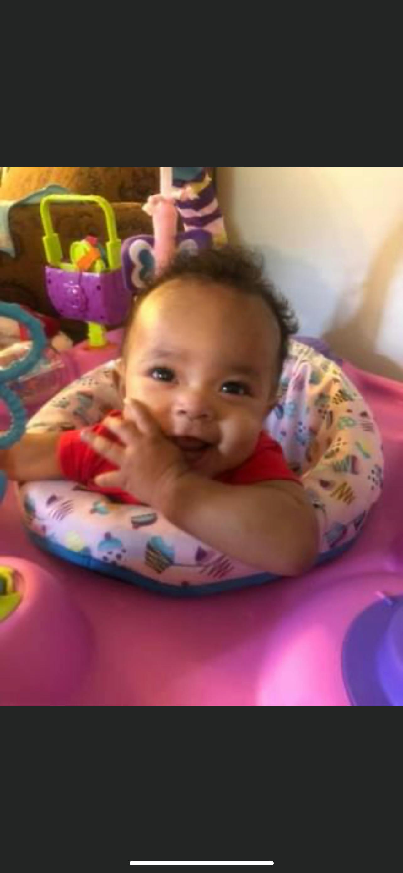 Child in a baby seat with hands near face