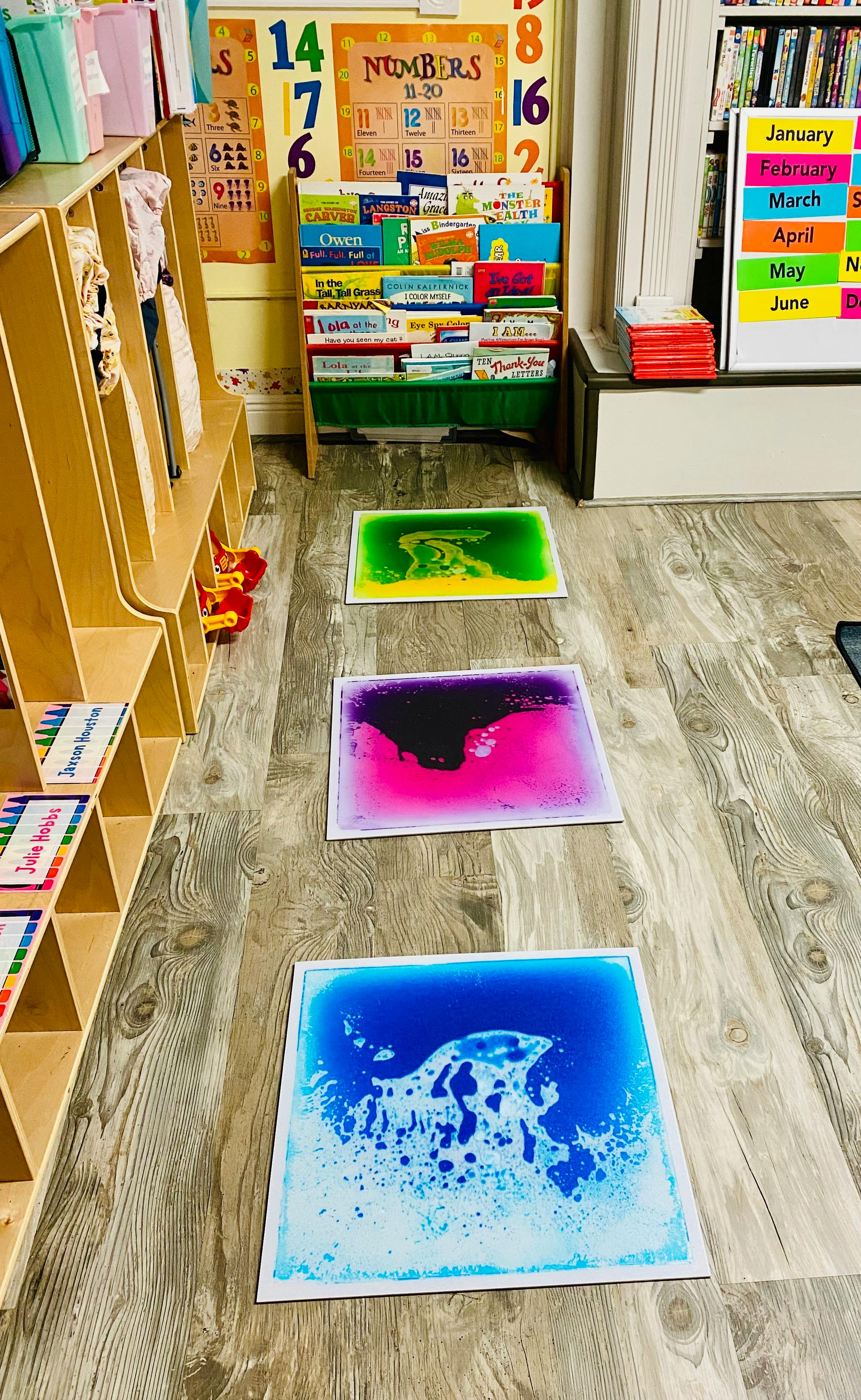 Three colorful liquid floor tiles in a classroom