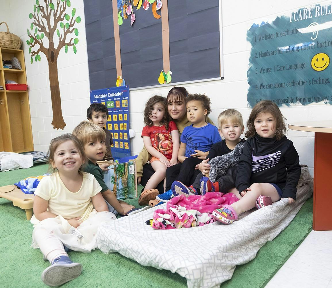 Adult and multiple children sitting together in a classroom