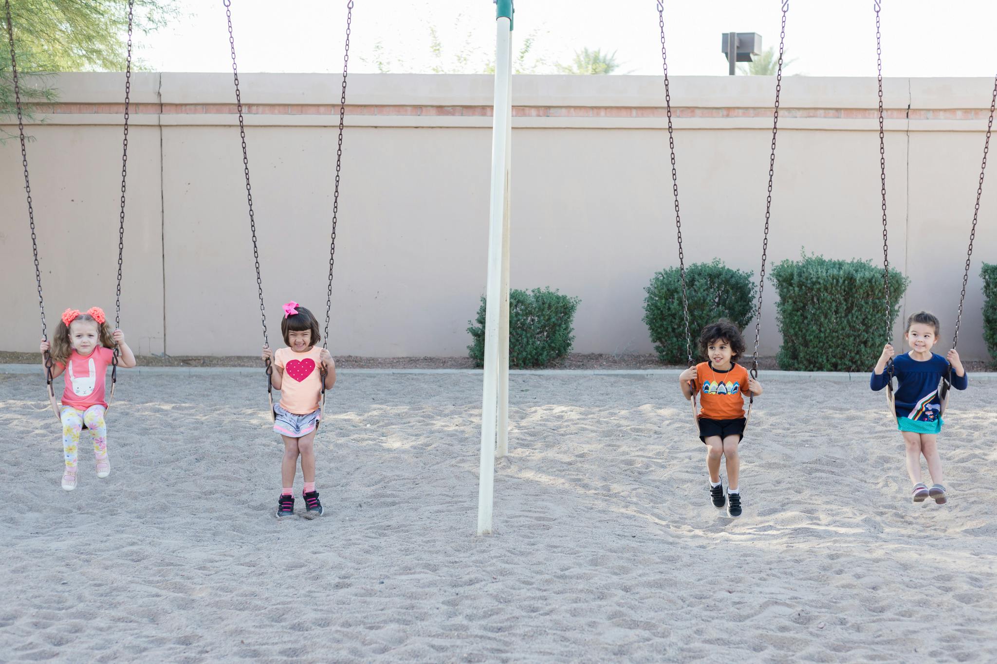 Four children on swings at a playground