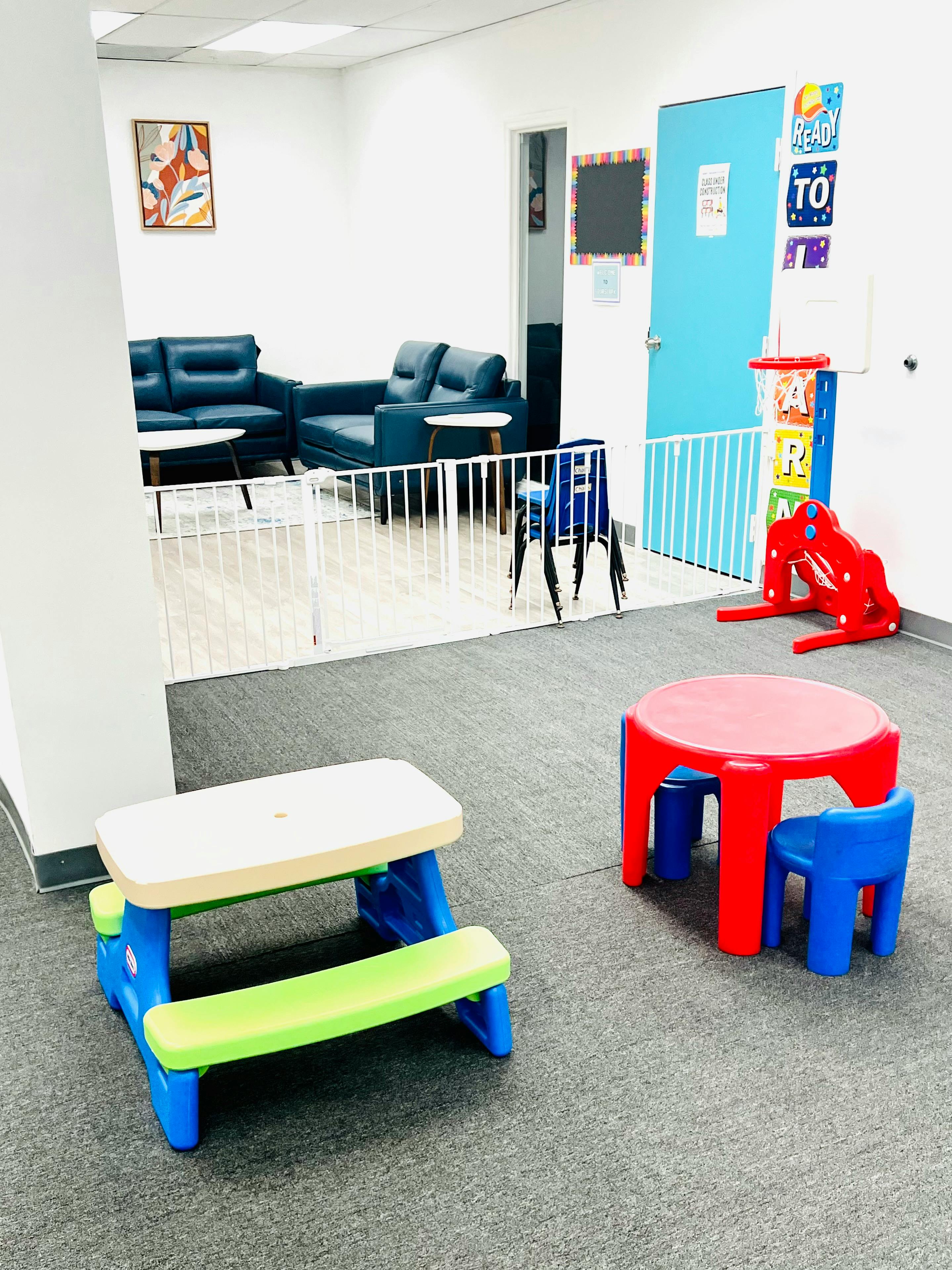 Children's play area with small tables and chairs, and a separate seating area