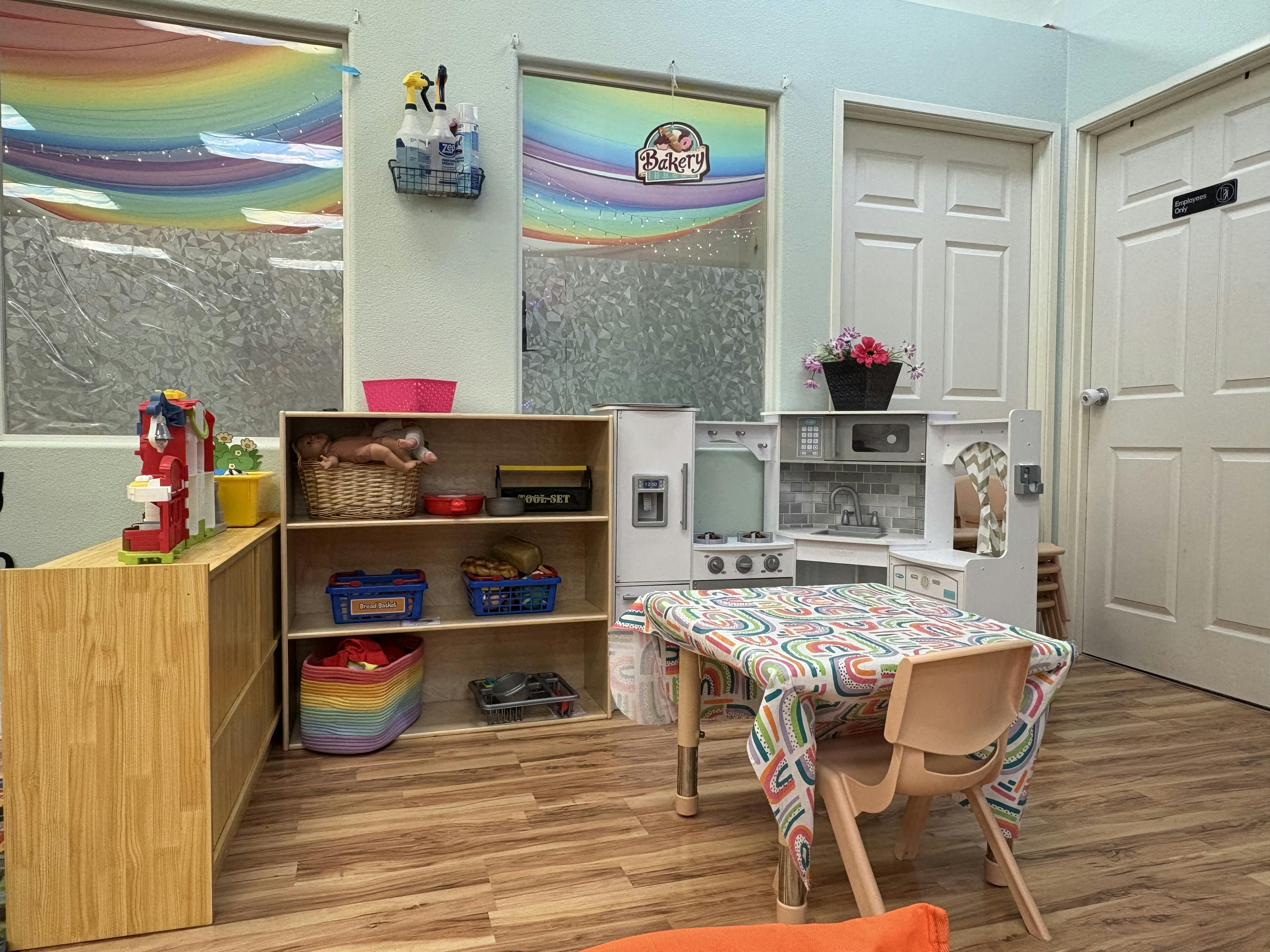 Playroom with toy kitchen, table and chairs, and storage shelves