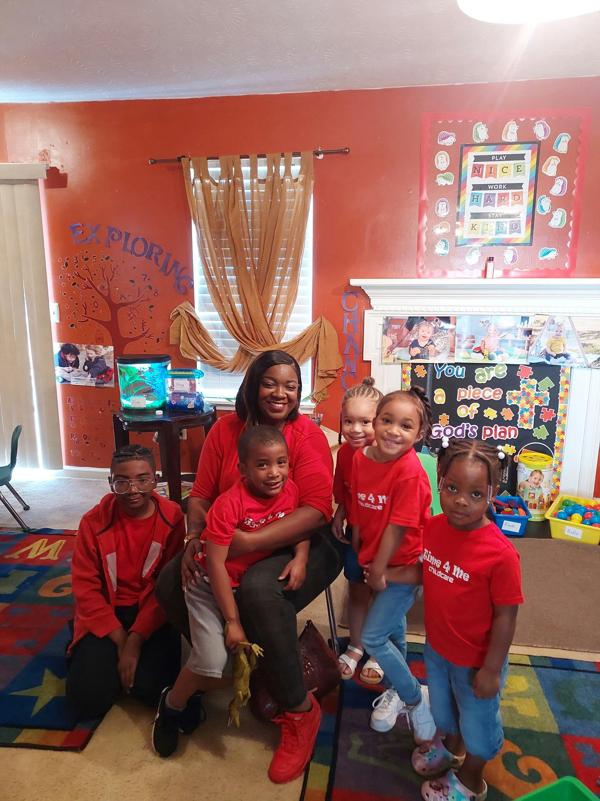 Adult and multiple children posing for a photo in a room