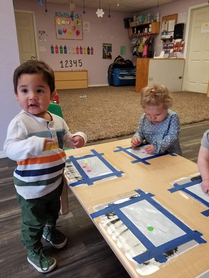 Two children playing at a table in a classroom
