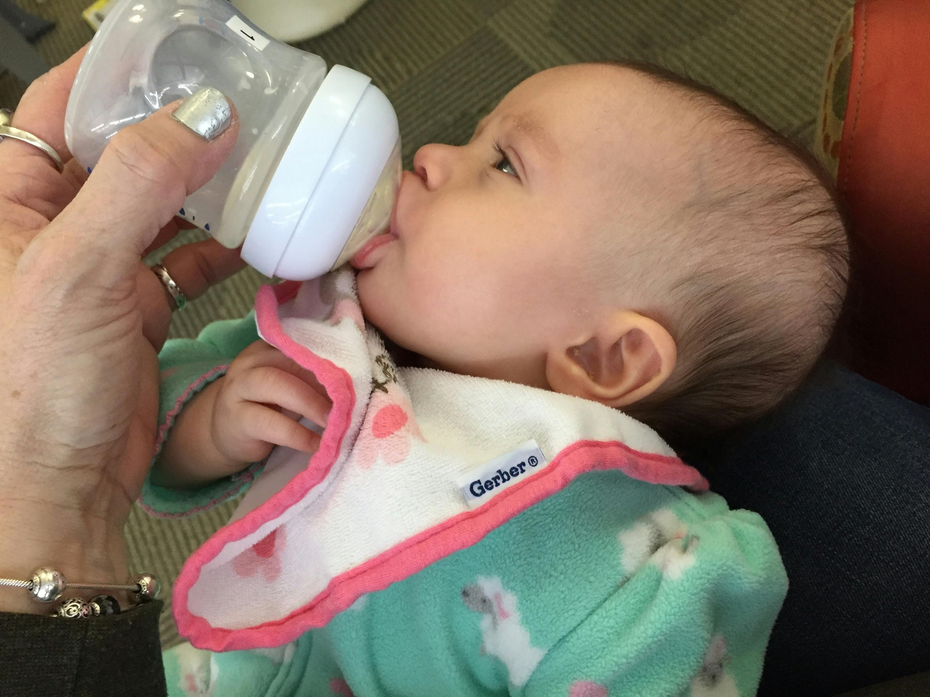 Person feeding a baby with a bottle