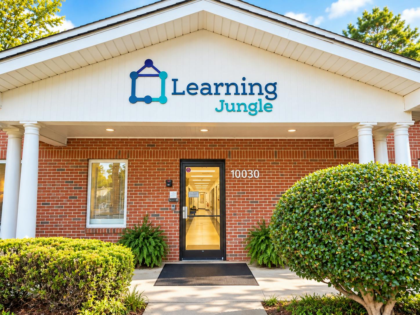 Brick building entrance with Learning Jungle sign and house number 10030