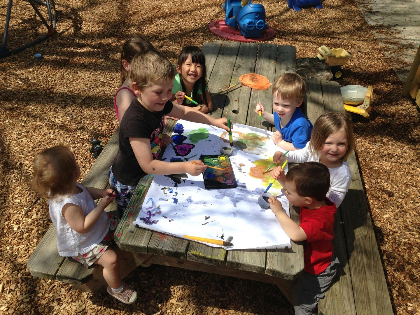 Children painting at a picnic table