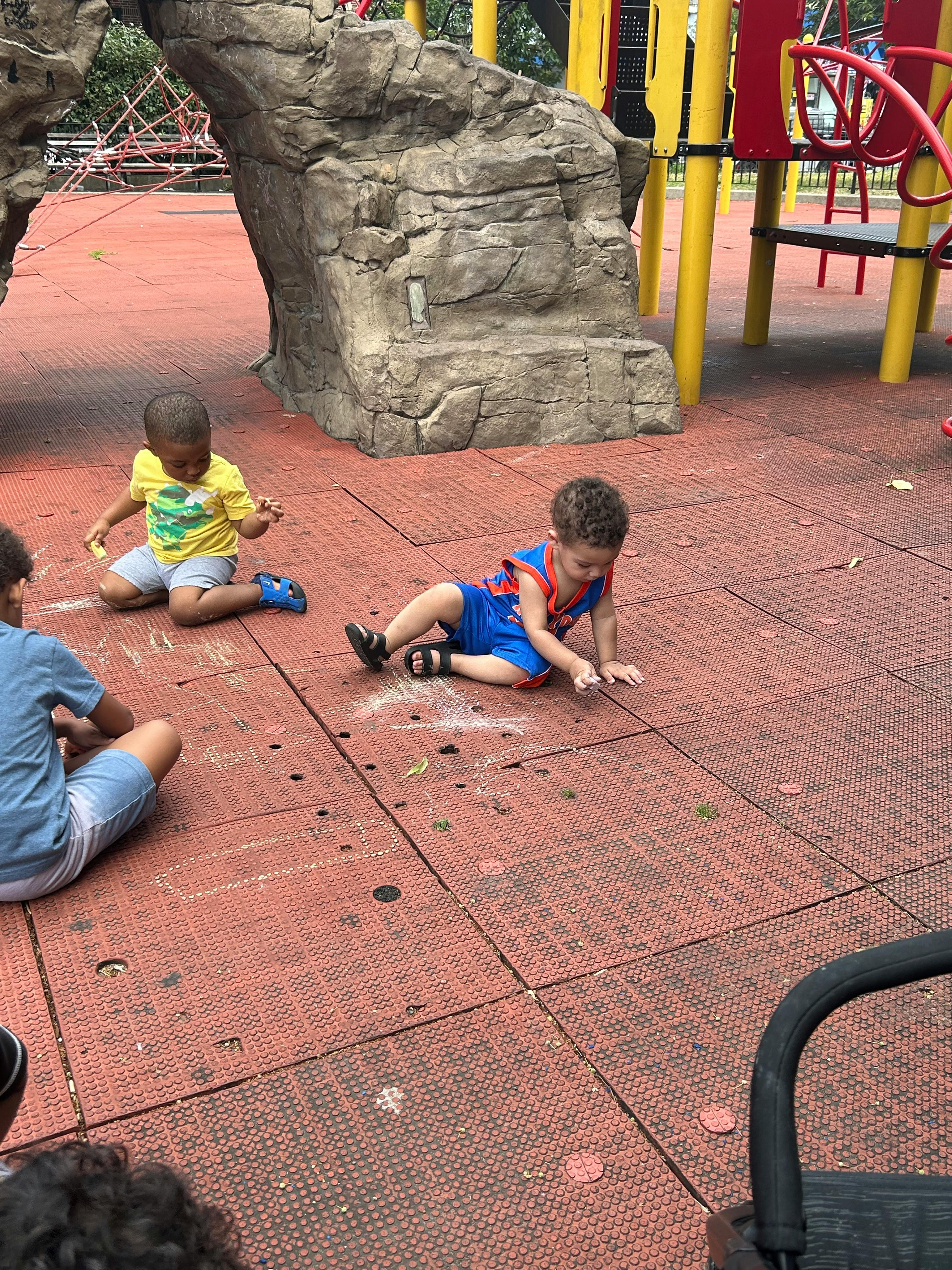 Children playing on a red playground surface