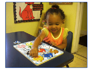 Child playing with a car puzzle at a table