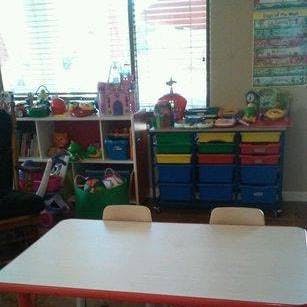 classroom with a table and shelves of toys