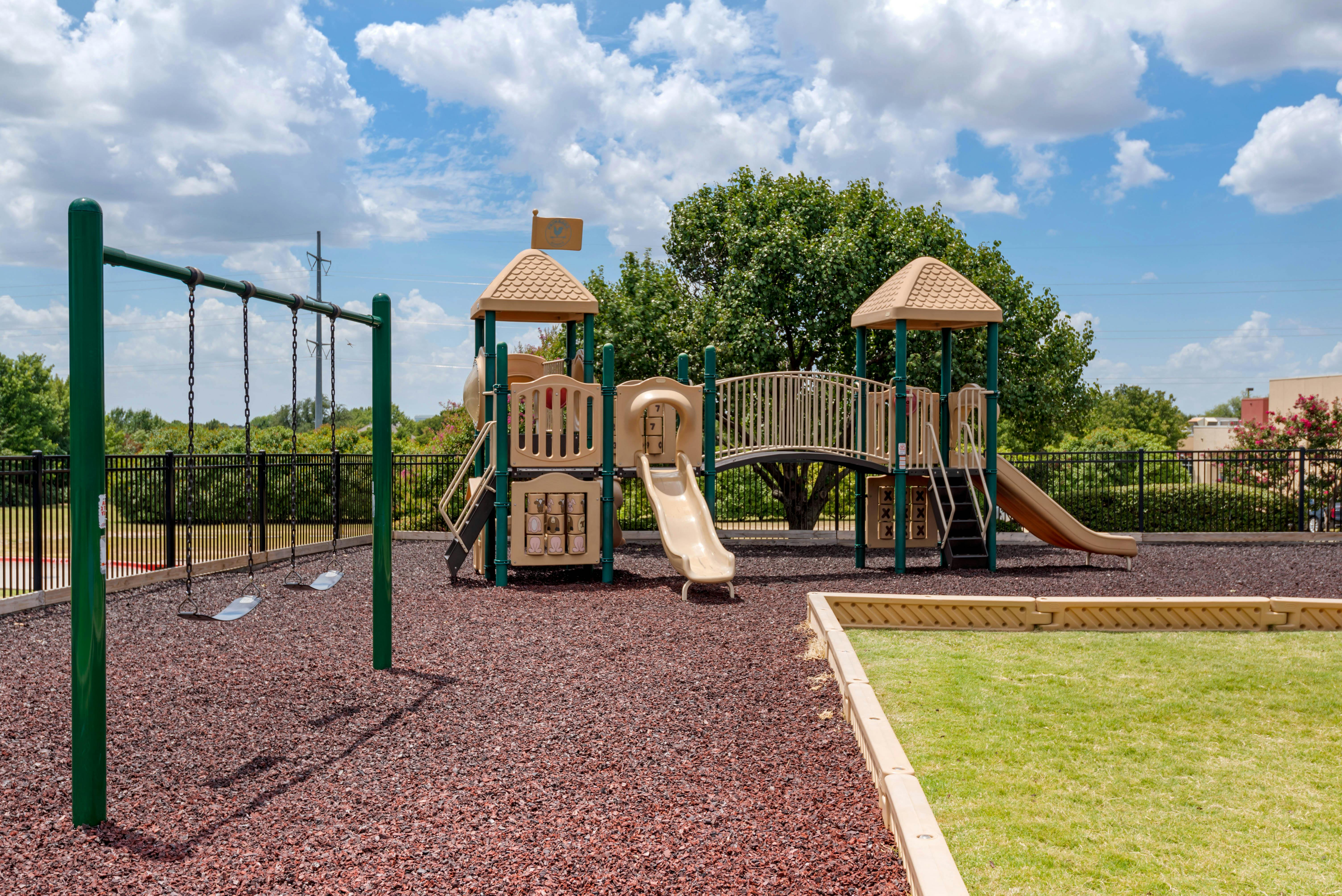 Playground with swings, slides, and climbing structures on a sunny day