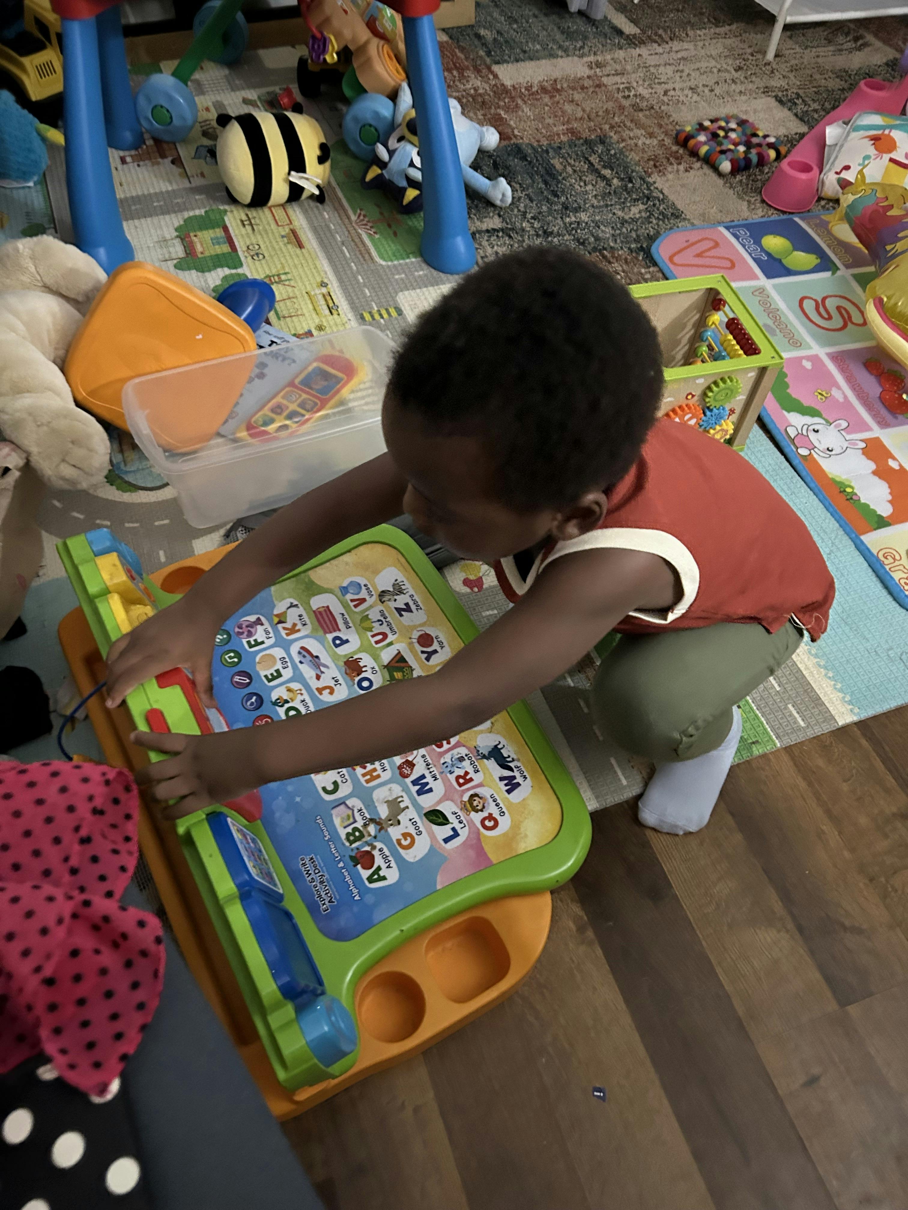 Child playing with an alphabet and letter sounds activity desk