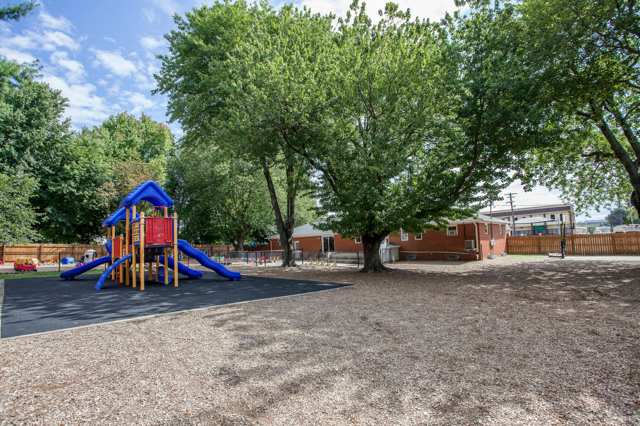 Playground with blue and red play structure and slides