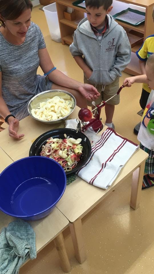 Person and child preparing food at a table
