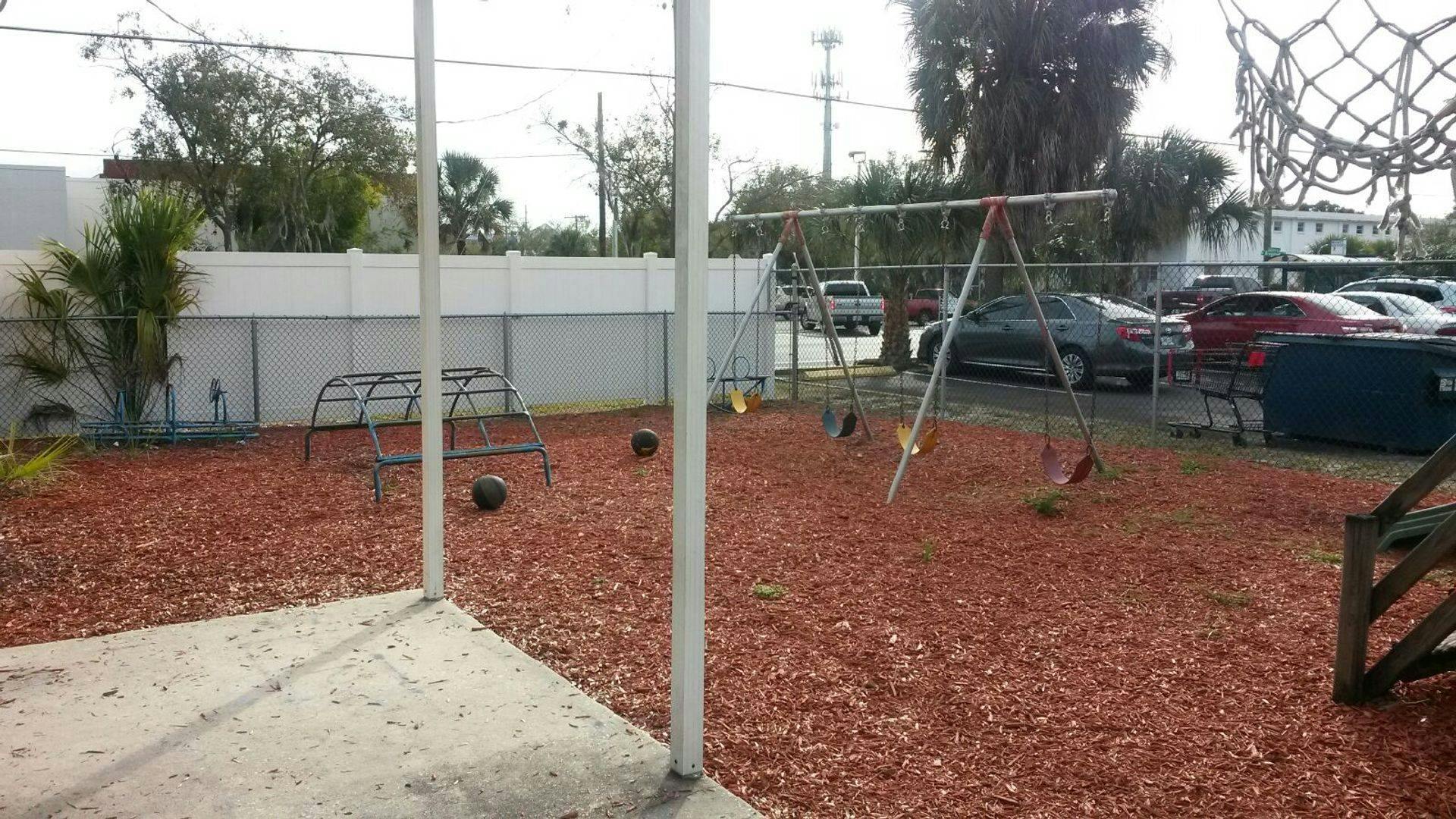 Empty playground with swings and red wood chips