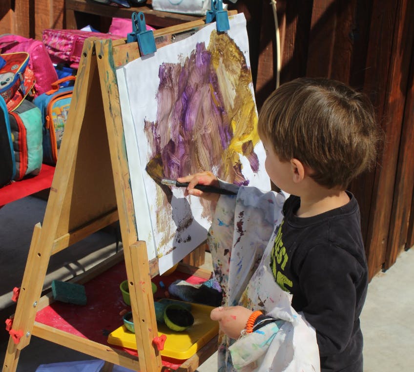 Child painting on an easel