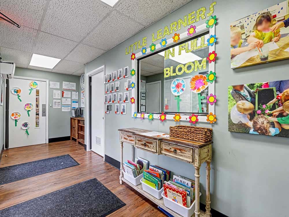 Entrance area of a learning center with a window decorated with text that says "Little Learners in Full Bloom"
