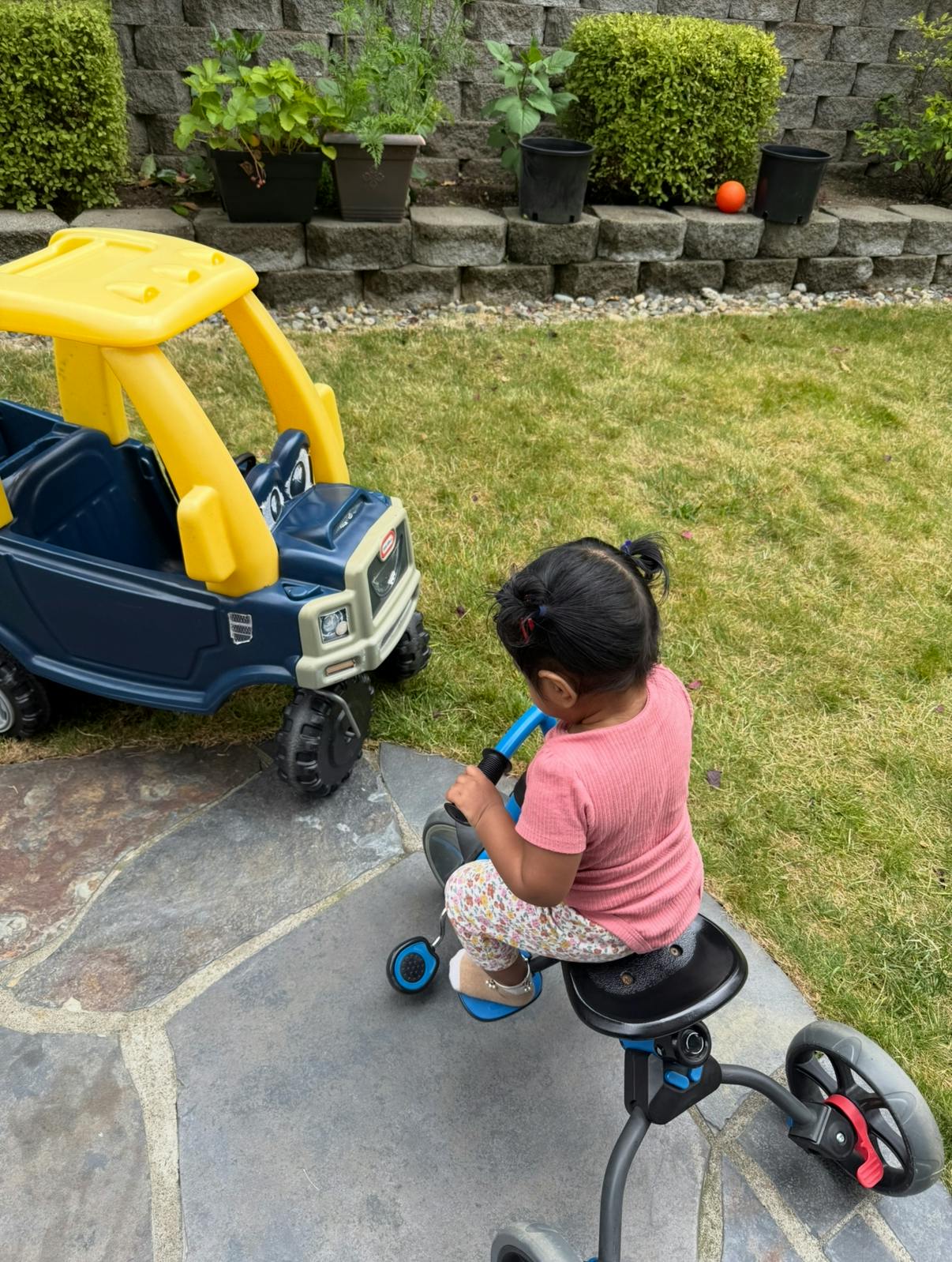 Child on a tricycle next to a toy truck