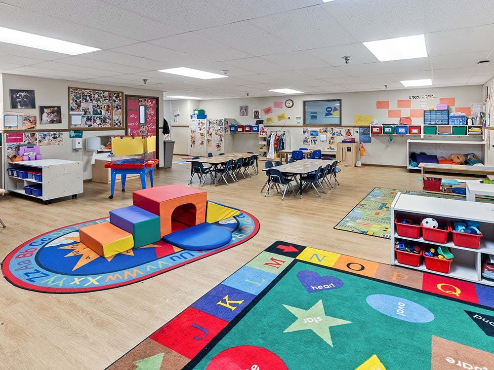 Colorful playroom with soft climbing blocks, small tables and chairs