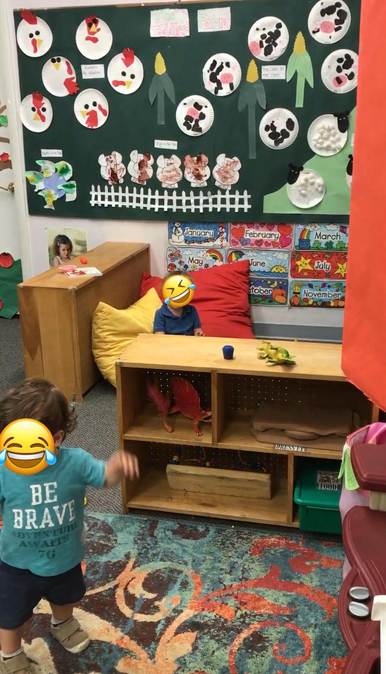 two children in a classroom with a farm-themed bulletin board
