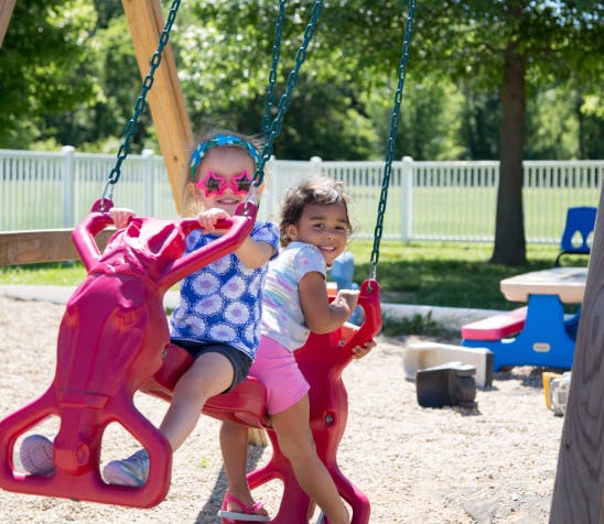 Two children on swings at a playground