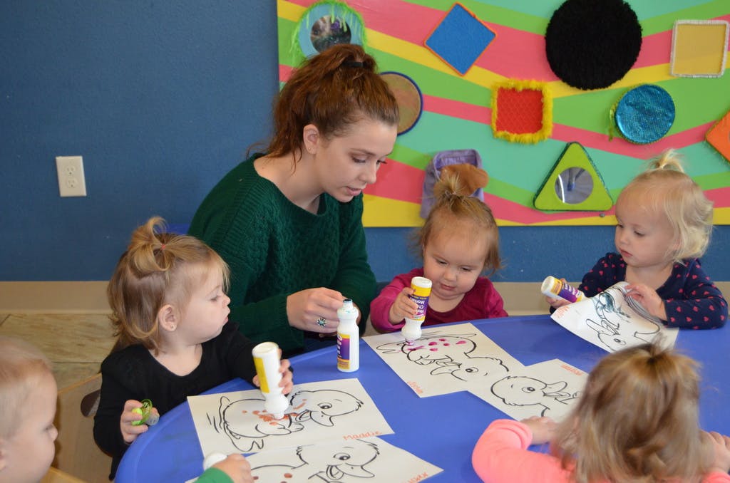 Adult and children coloring at a table